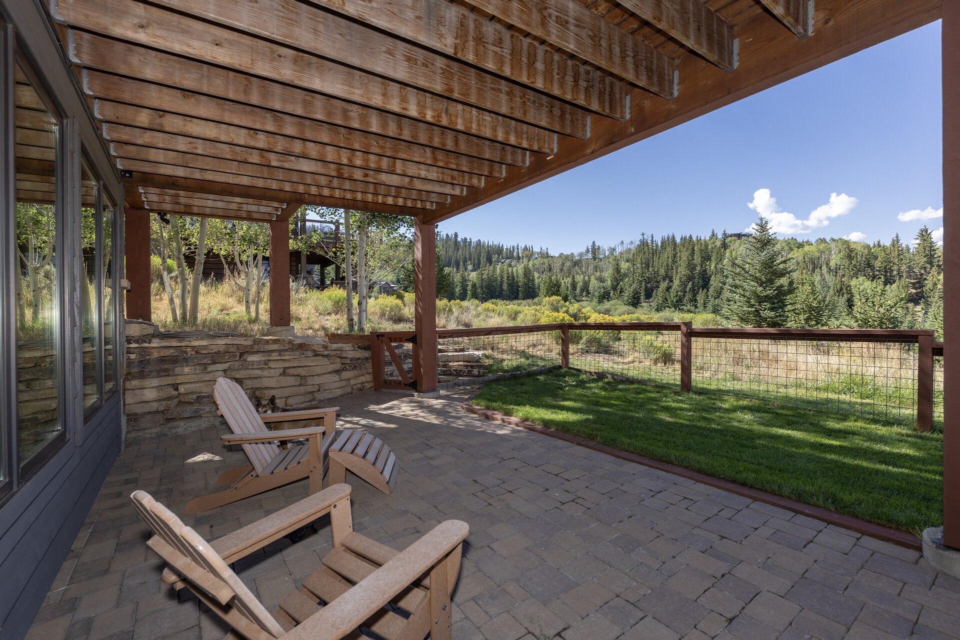 Covered paver patio and fenced backyard