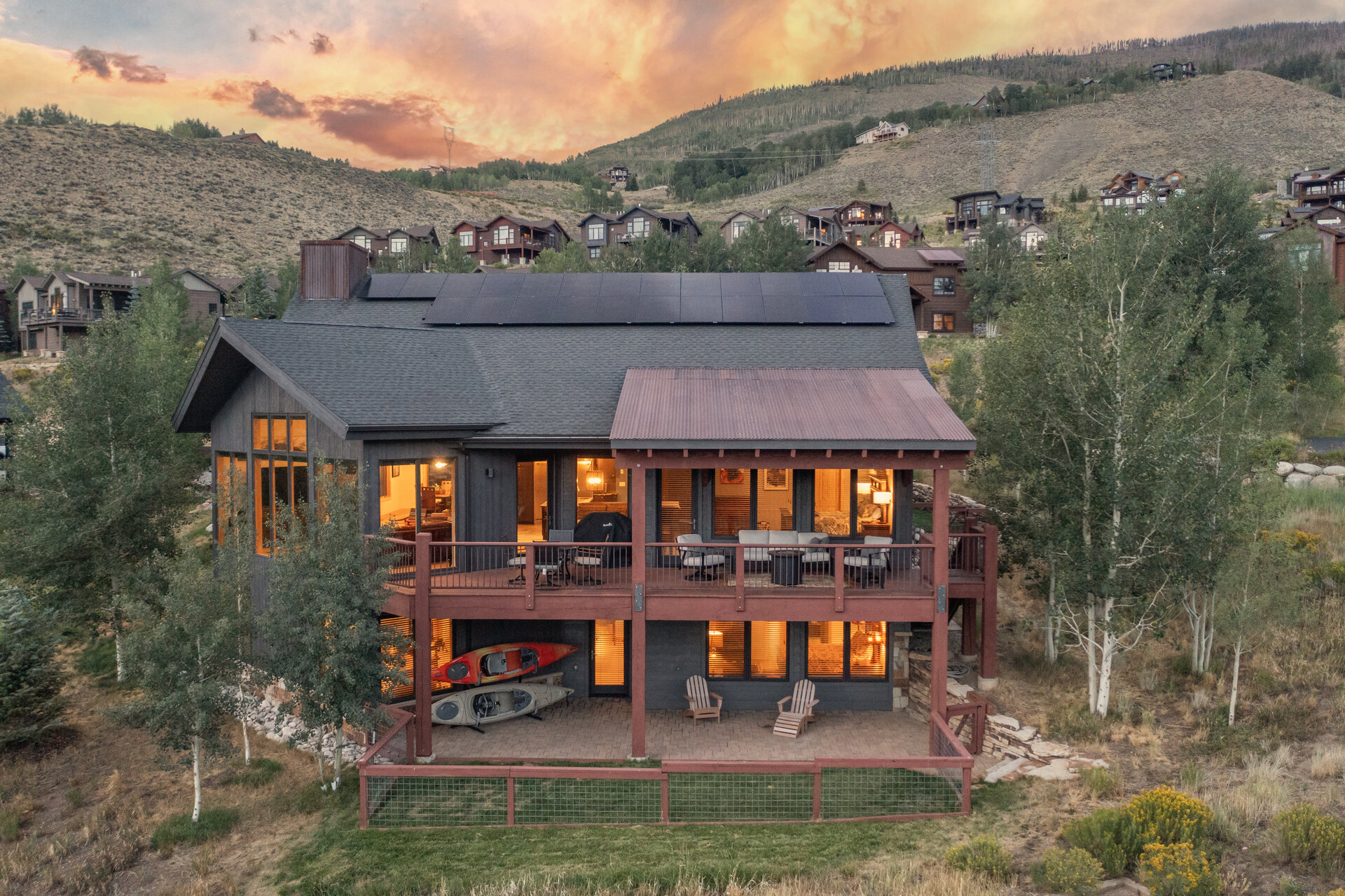 Rear of the home lit up at twilight with the decks