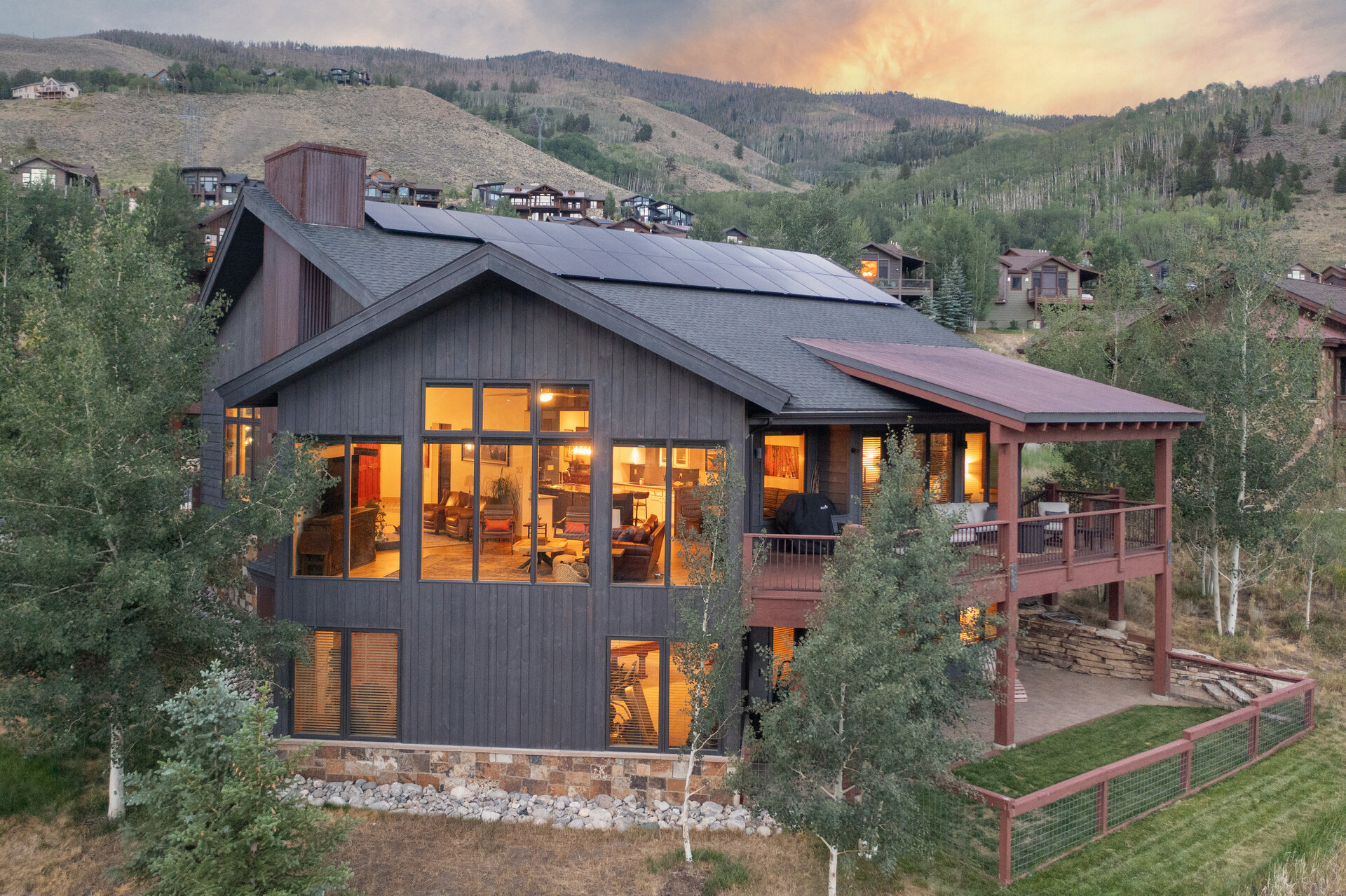 The rear of the home lit at twilight against the range