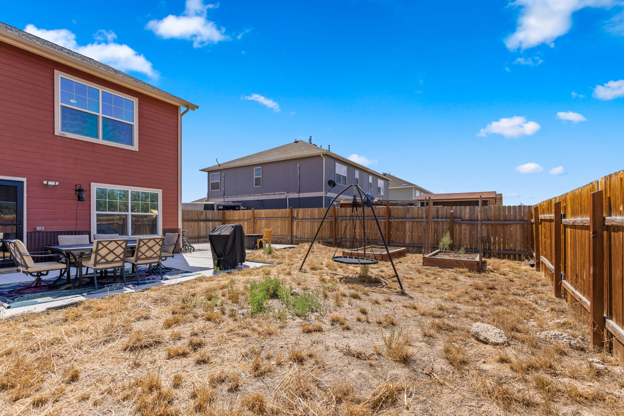 Fenced backyard and rear elevation of the Kremmling home