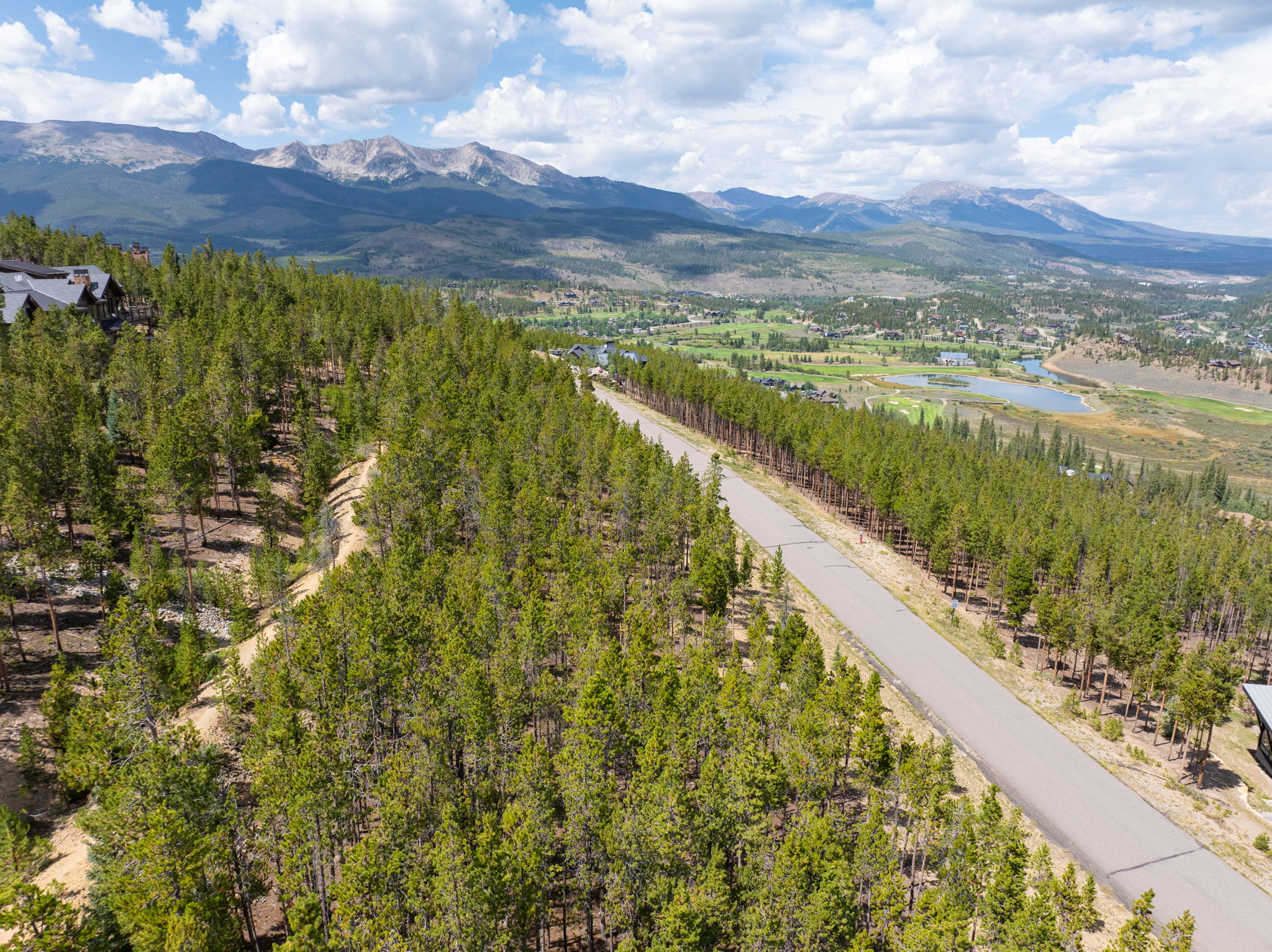 Open view over the treetops toward the golf course ponds and the Tenmile Range