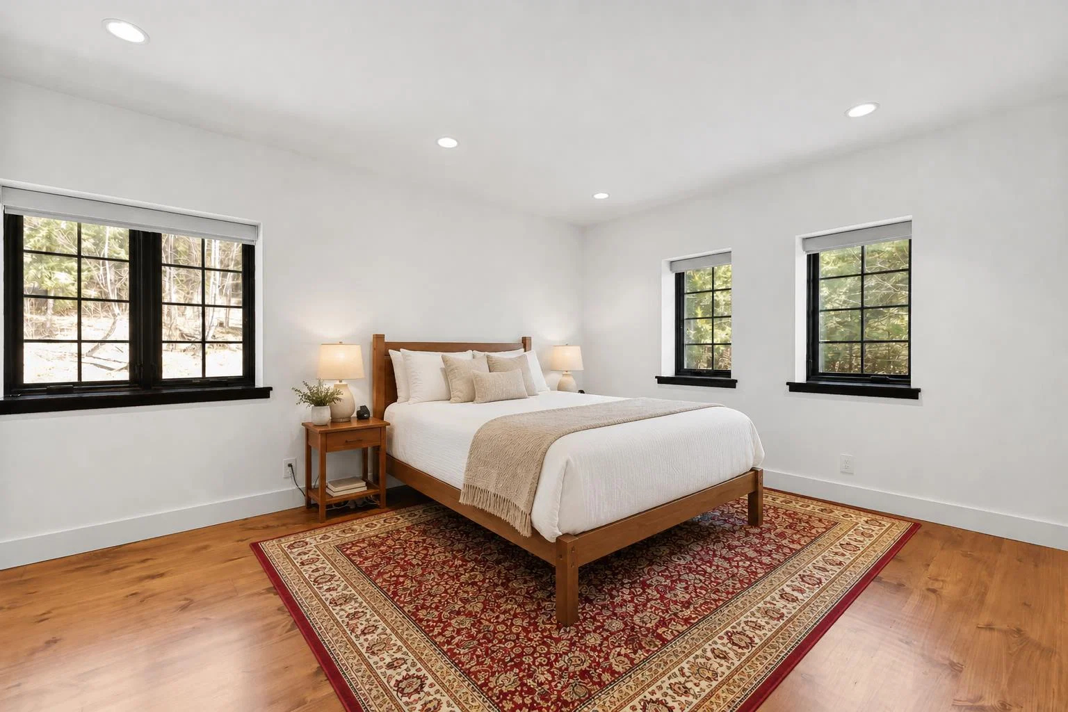 Luxury Vermont bedroom with warm wood floors and black-trim windows