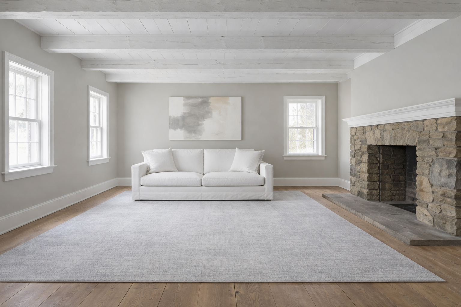 Vermont farmhouse living room staged in modern minimalist style: original pine floors hidden under grey rug, hand-hewn beams painted white, walls in greige, white slipcovered sofa, bare mantel, cold flat lighting &mdash; instructional contrast image