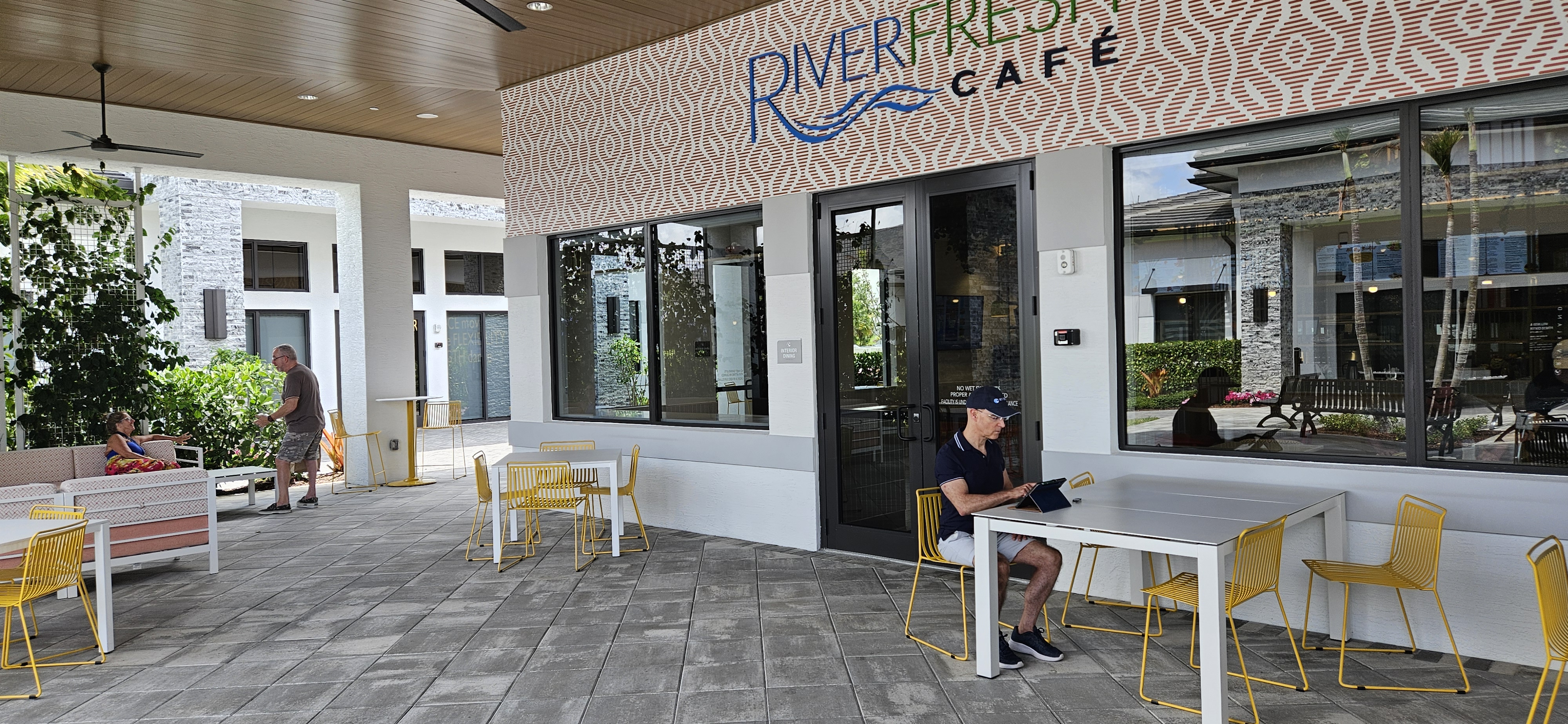 Thom Montrois working on his tablet during a beautiful day at the outdoor seating area of RiverFresh Cafe in Riverland, Port St. Lucie