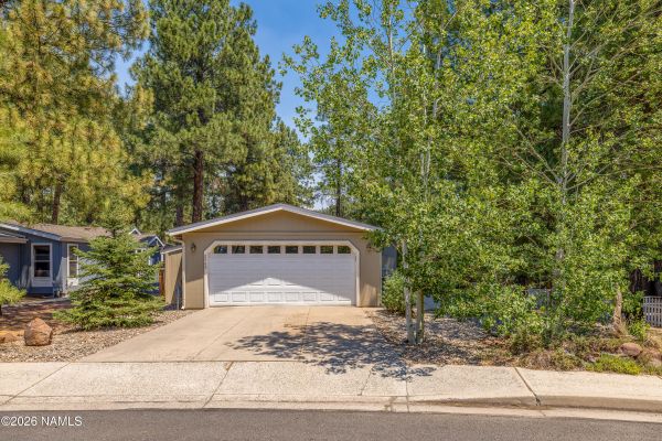 Exterior of 2460 W Rio Grande Ct, a single-level home surrounded by Ponderosa pines in the Railroad Springs neighborhood of Flagstaff, AZ