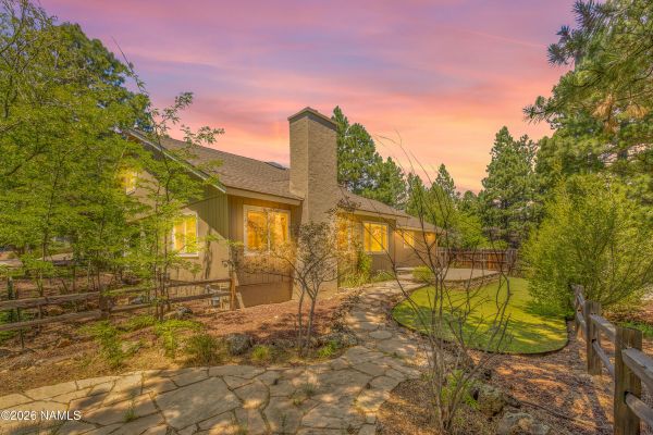 Fully fenced backyard with tiered concrete patio, paver patio, and apple trees at a Flagstaff, AZ home for sale
