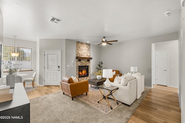 Open living area with gas fireplace and vinyl plank flooring at 10226 Lundin Rd, Flagstaff, AZ
