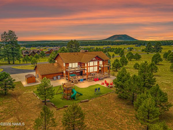 Luxury mountain home for sale in Flagstaff AZ &mdash; log-sided exterior of 8900 N Snowbowl Ranch Rd on 4 wooded acres