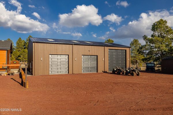 Massive insulated steel garage workshop with car lift and storage space on Northern Arizona acreage estate