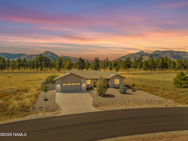 Single-story home with wide concrete driveway and rock landscaping on 1.67 acres at 10226 Lundin Rd, Flagstaff, AZ