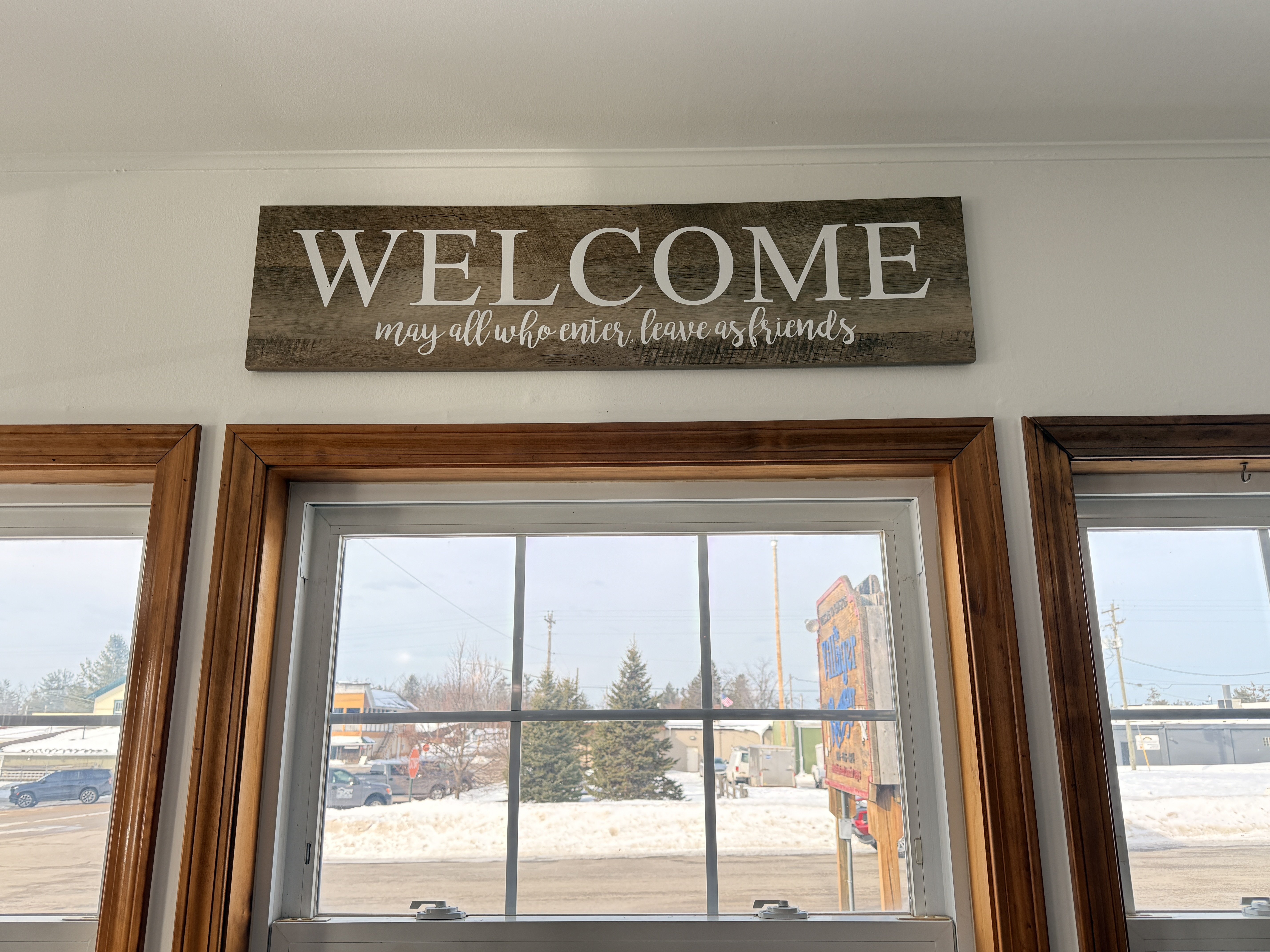 Welcome sign at The Villager Restaurant reading 'May all who enter leave as friends' - Lewiston Michigan - Huston Real Estate