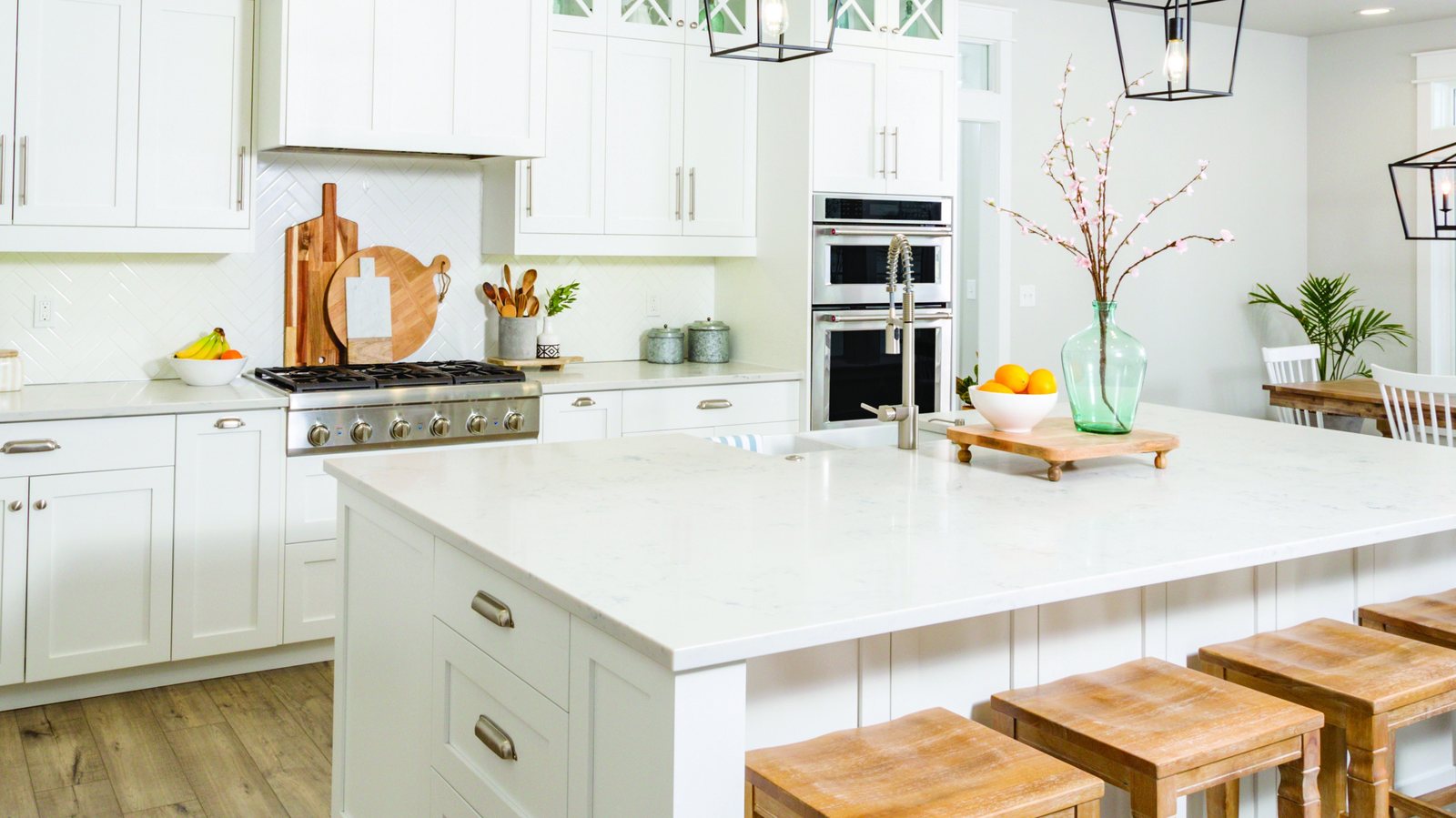 White kitchen with a large island and wood bar stools