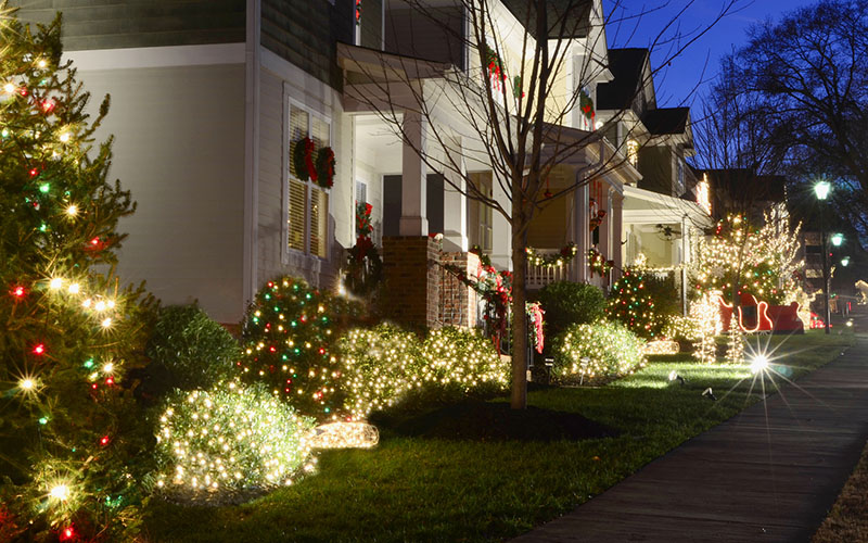 Suburban house decorated with holiday lights at night