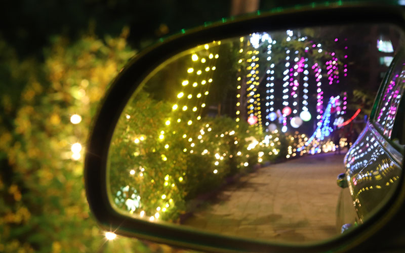 Drive-through holiday light display seen through a windshield