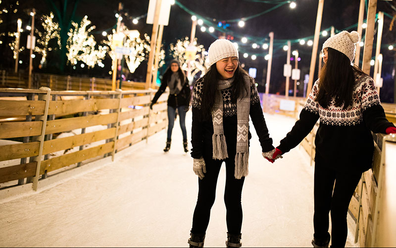 Curving outdoor ice skating ribbon lit by holiday lights