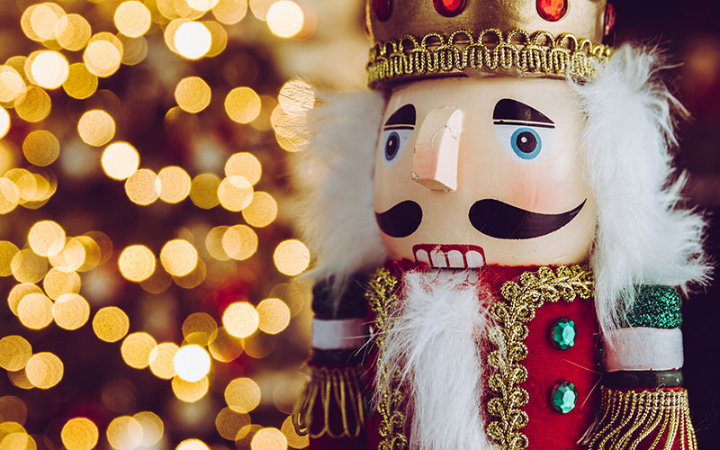 Nutcracker figurine against warm holiday lights
