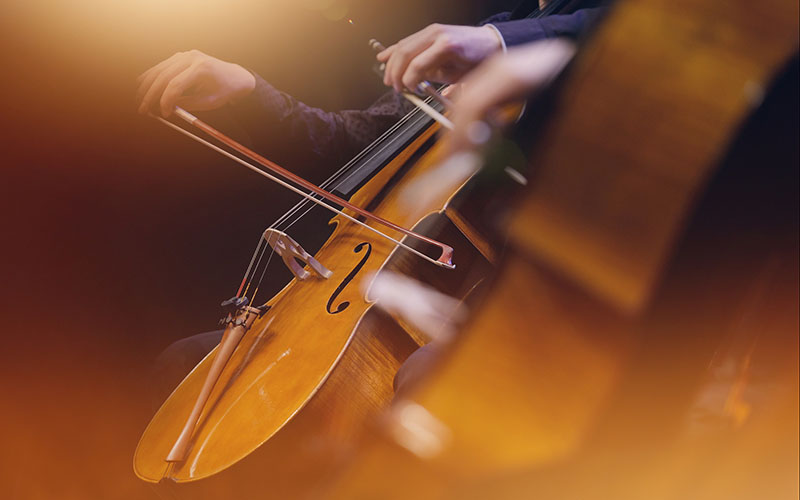 Cellists performing in warm stage light