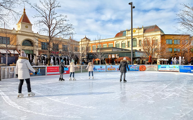 Outdoor ice skating rink surrounded by holiday lights