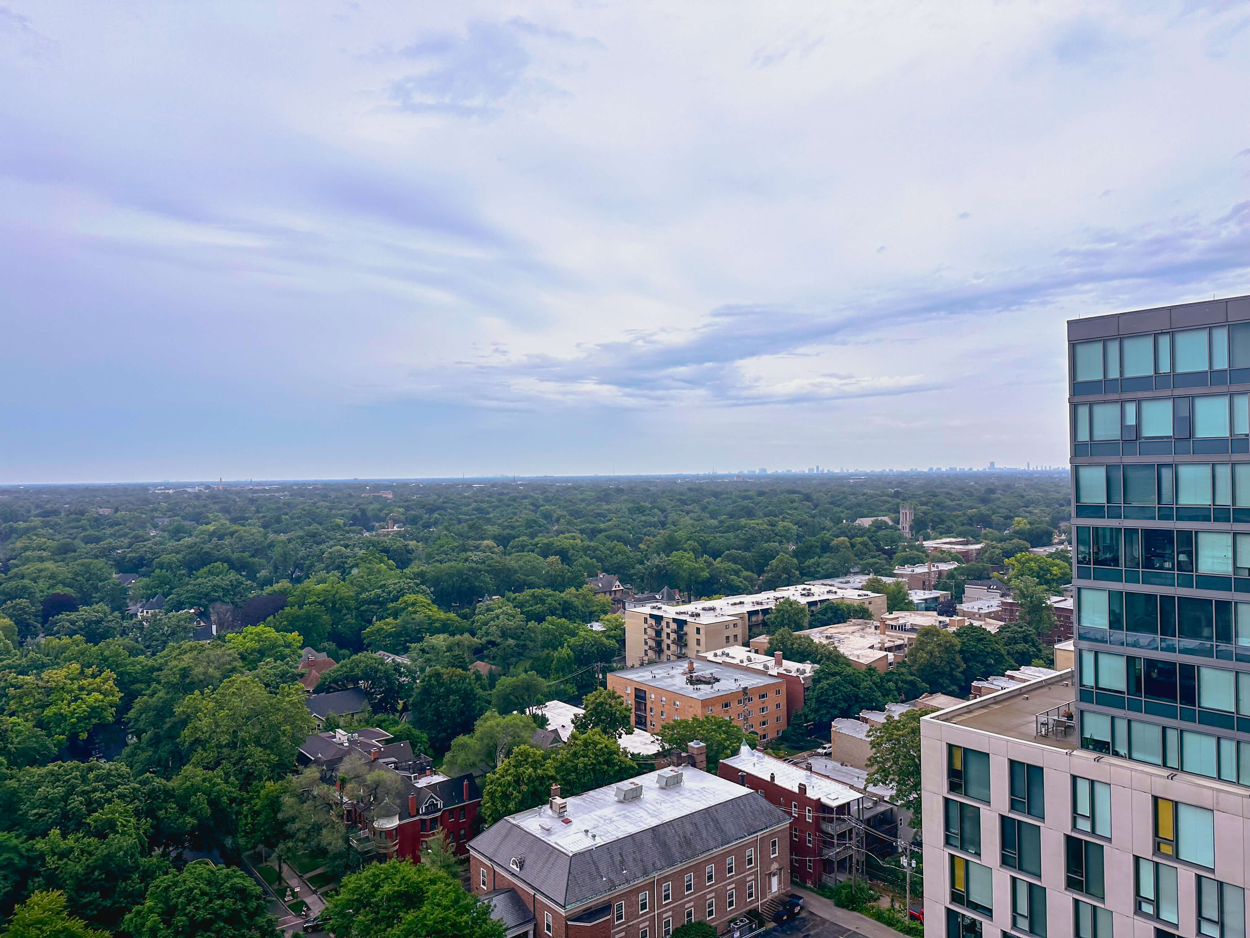 View over Oak Park Illinois with Chicago skyline visible in the distance, showing the tree-lined neighborhoods west of Chicago