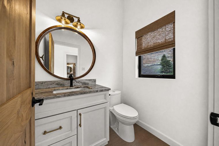 Powder room with a circular mirror at 1731 Marina Estates Road