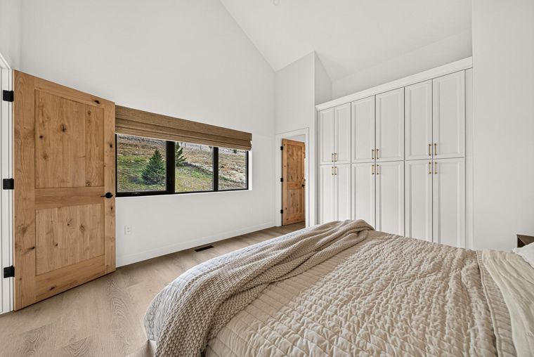 Primary bedroom with wood doors and a wide window at 1731 Marina Estates Road