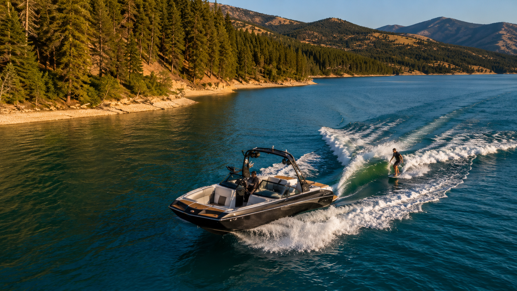 Lake Koocanusa BC wakeboating on turquoise water with pine forest and mountains in the background