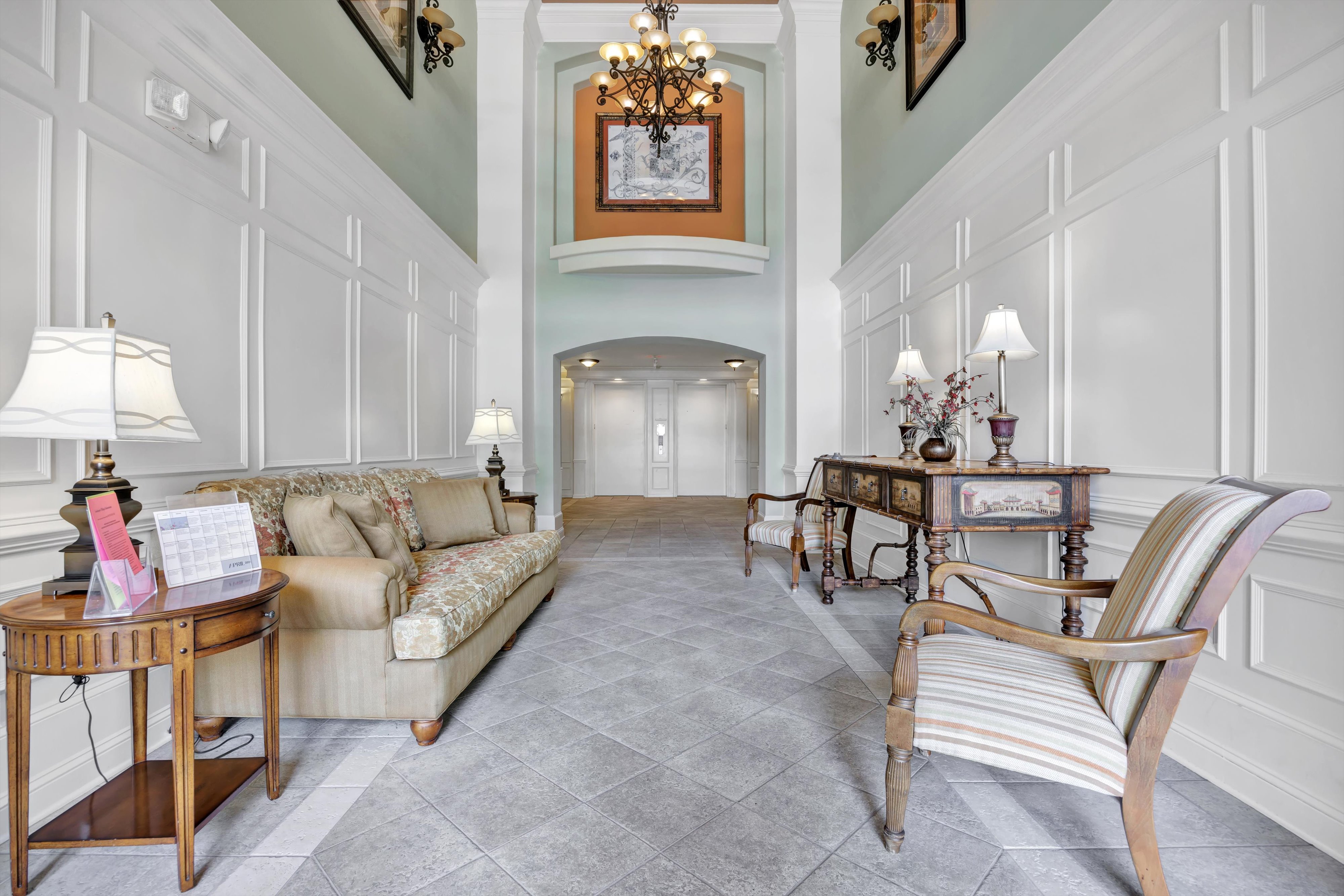 Interior entrance of a Sandpiper Village mid-rise building with elevator access at Sweetwater by Del Webb