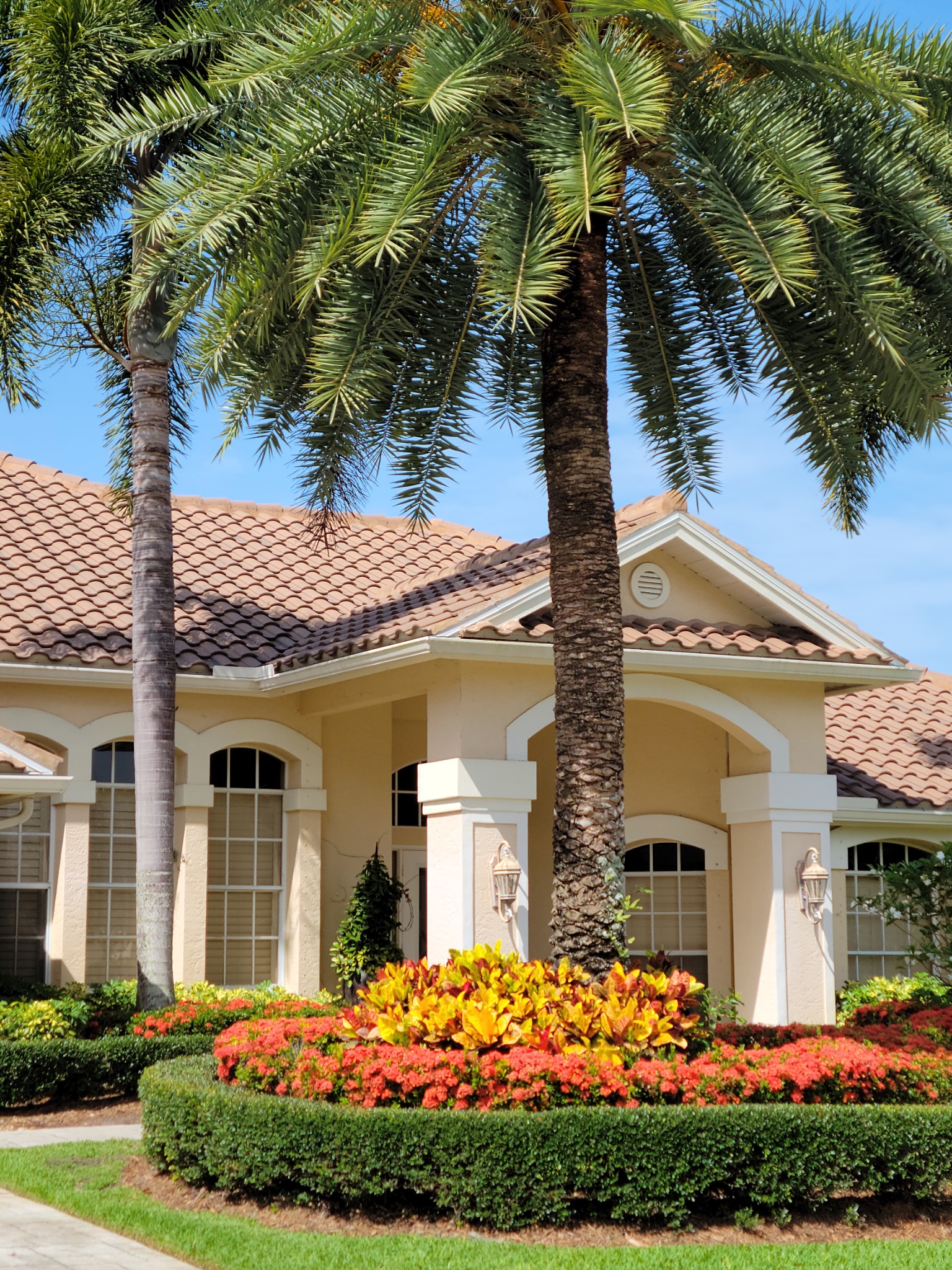 Florida home in October with palm trees and colorful landscaping