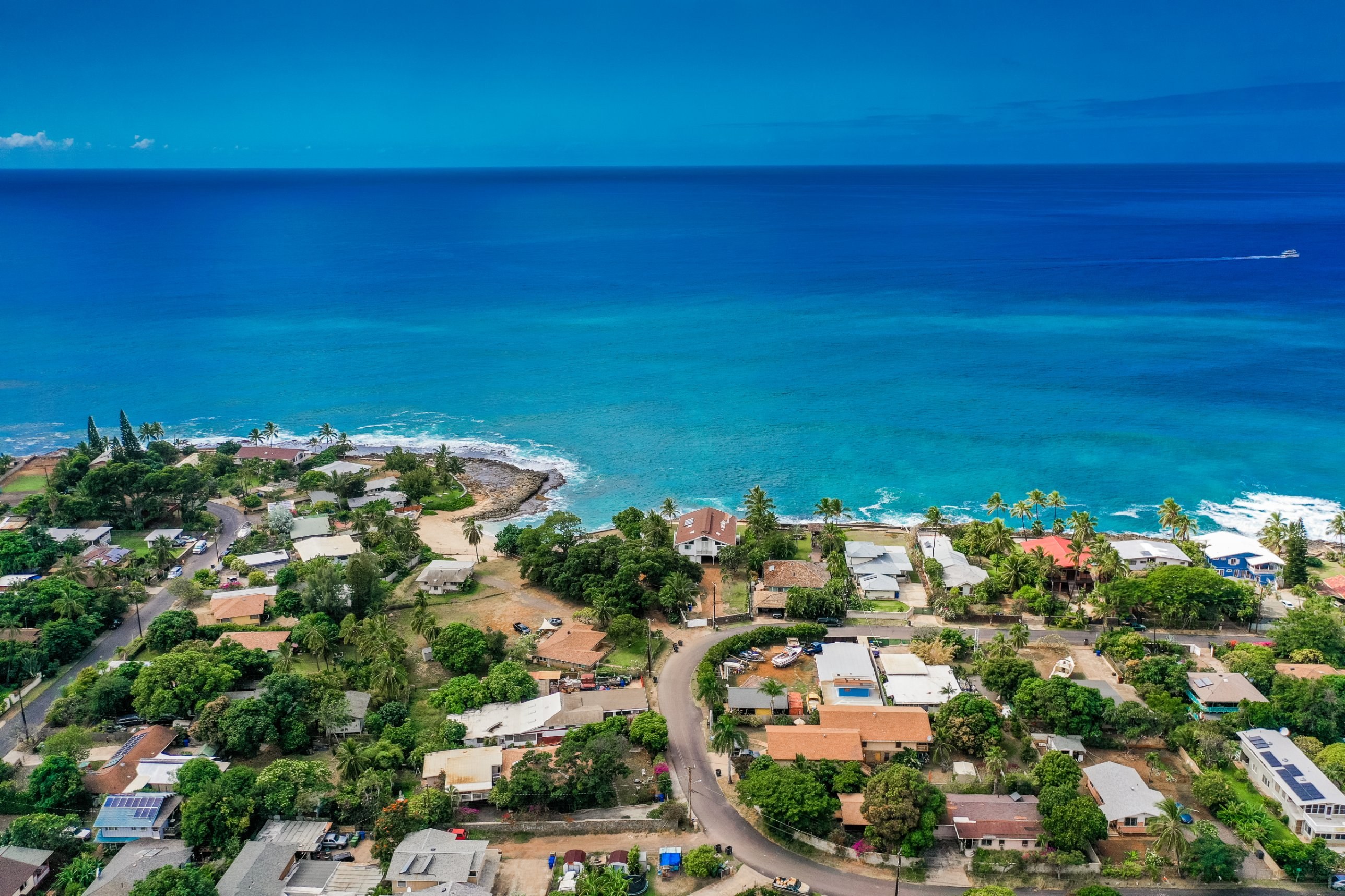 Aerial of an oceanfront neighborhood with a rocky point on the Waianae Coast