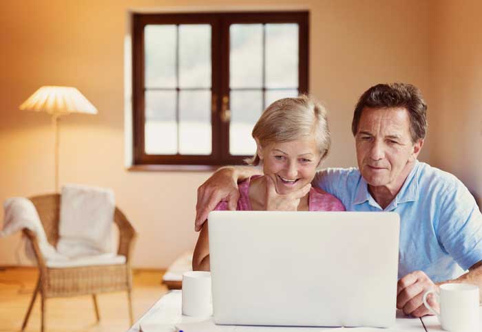 Senior couple looking at home valuation report on computer