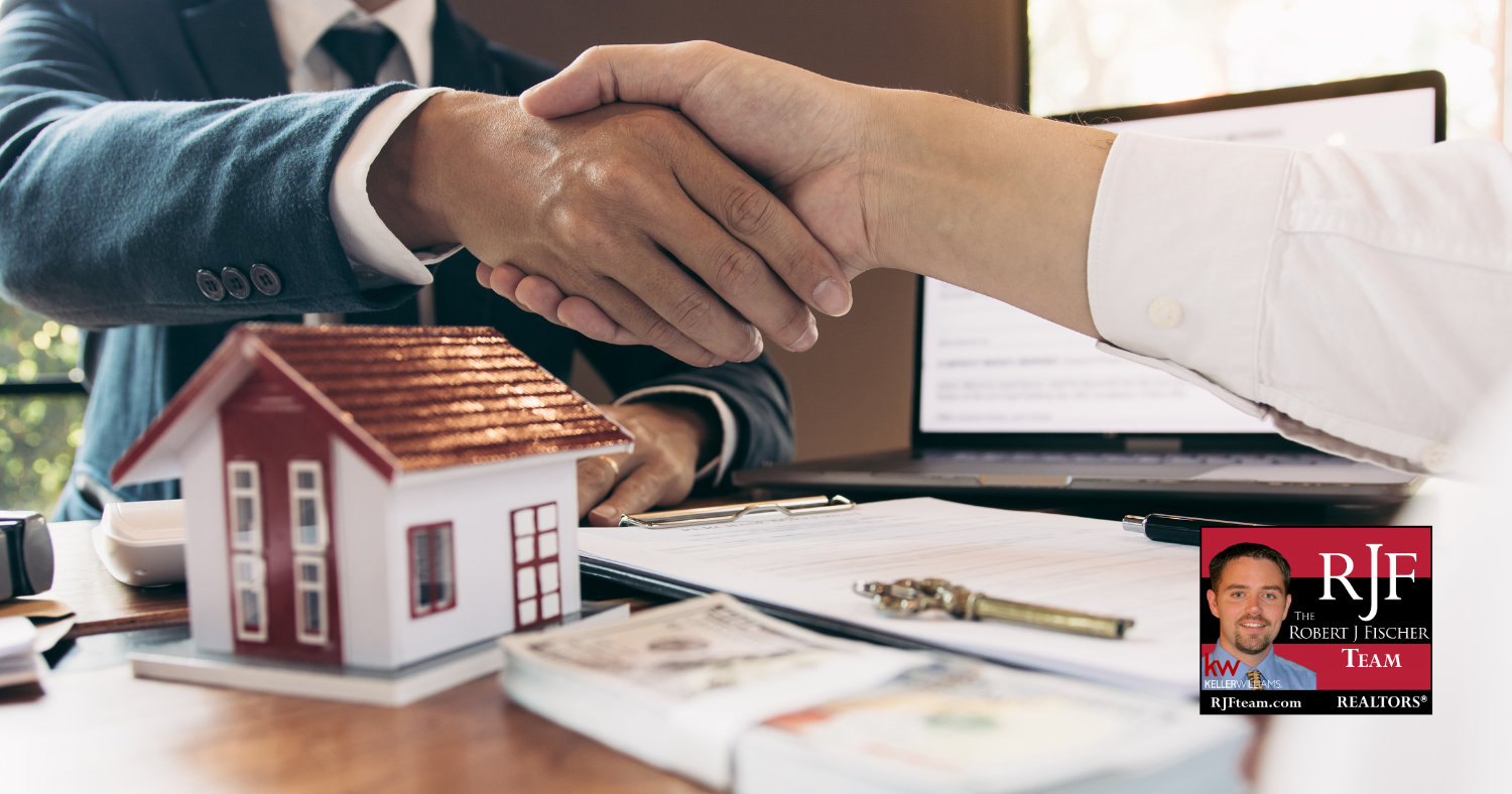 A realtor and client shaking hands as they go over real estate predictions for 2025 with the Robert J Fischer Team logo in the bottom right corner.