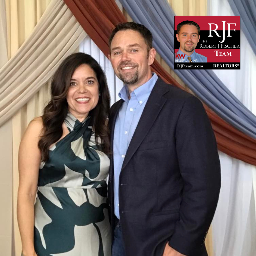 Robert and Michelle Fischer of The Robert J Fischer Team, smiling together in front of a light background with the Robert J Fischer Team logo displayed in the top right corner.