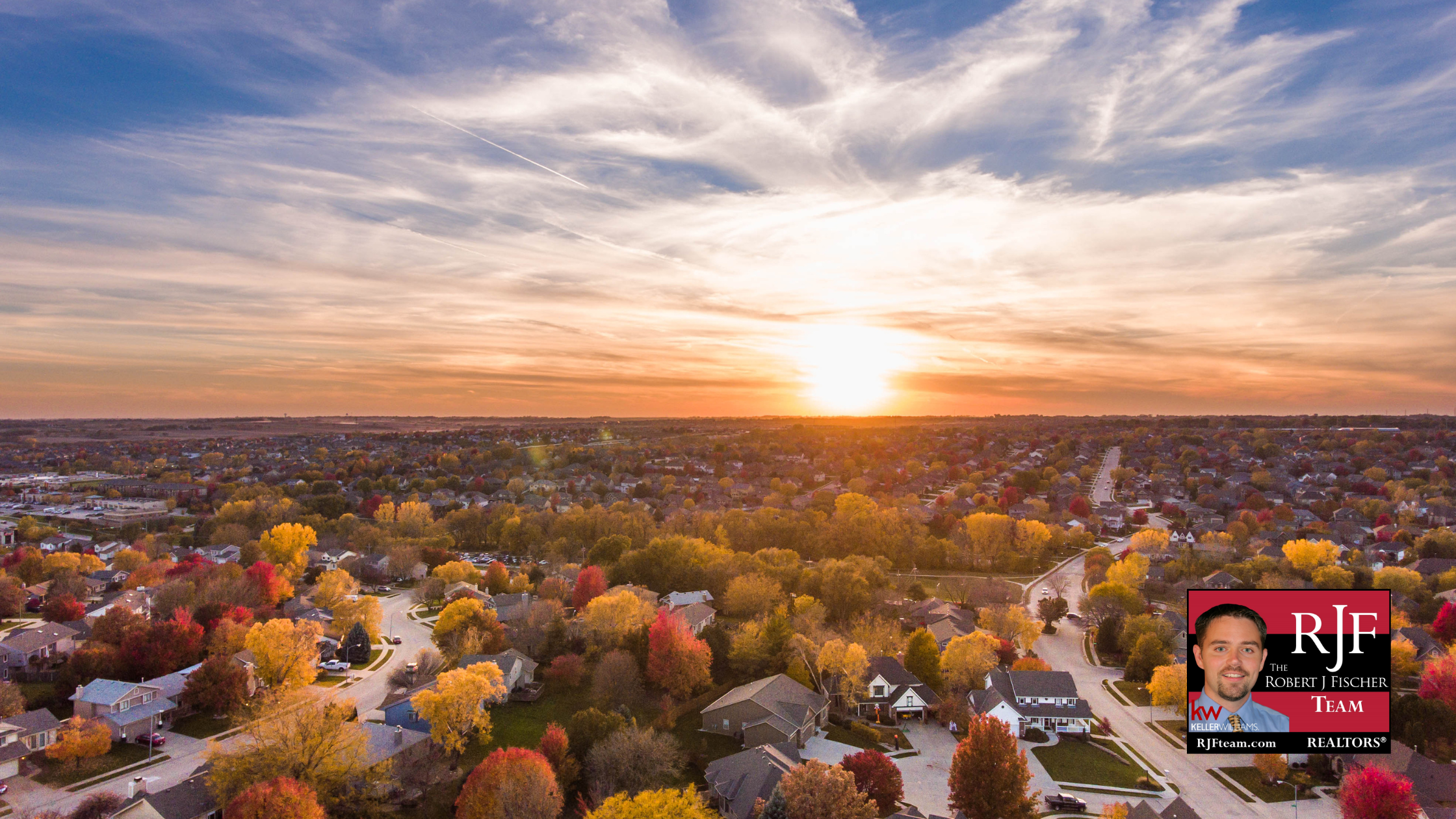 An aerial view of a neighborhood with autumn colors and the Robert J Fischer Team logo in the bottom right corner.