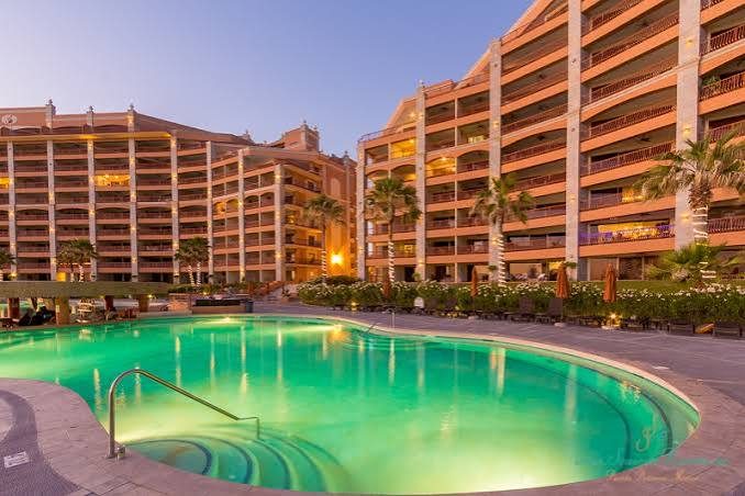 Sonoran Sun towers and pool lit up at dusk