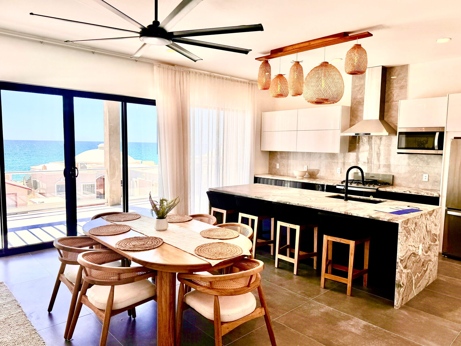 Kitchen with marble waterfall island and ocean view at Vista Del Mar
