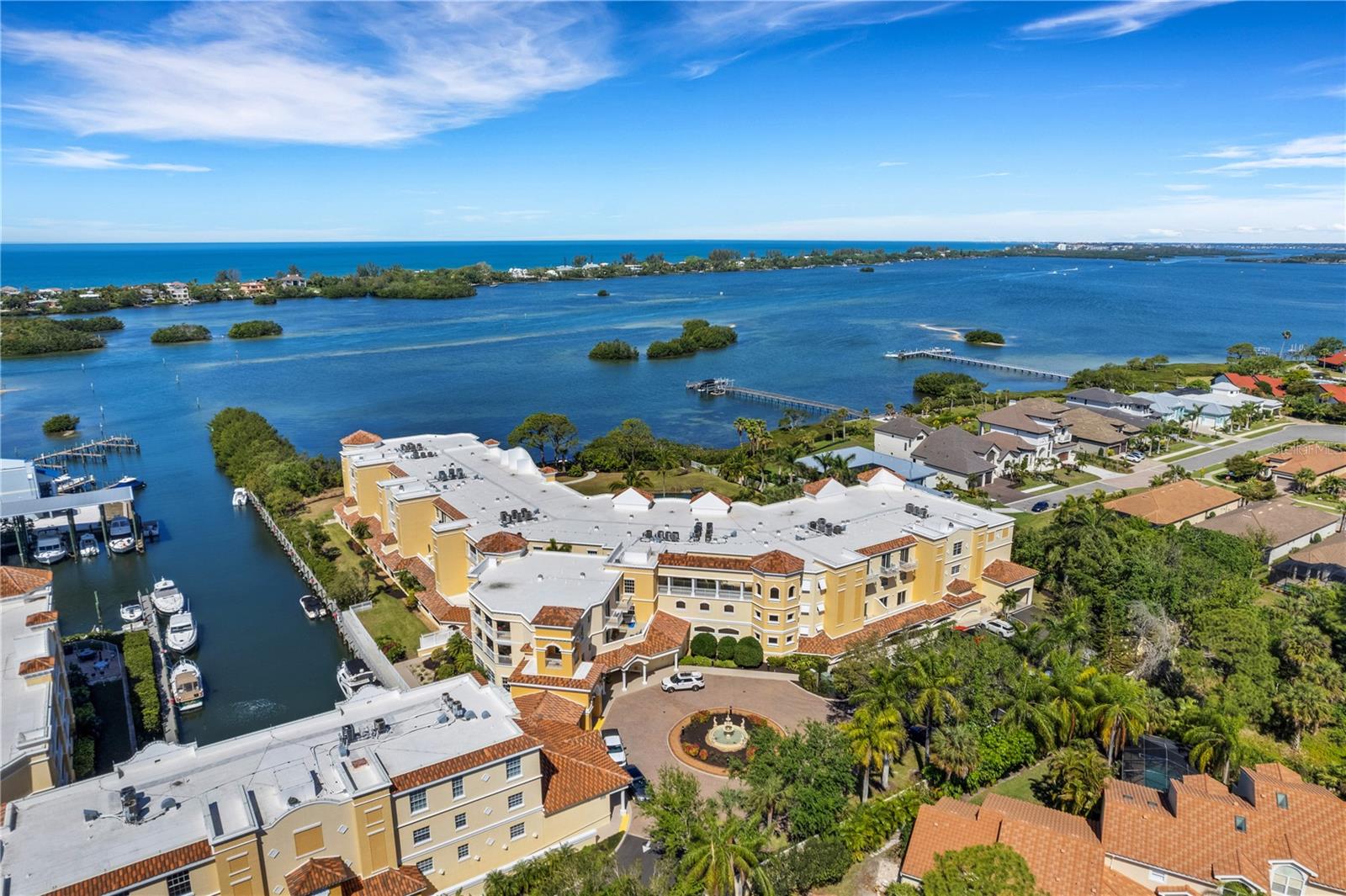 Aerial view of Bellagio in Osprey, Florida, a waterfront condominium community with boat slips, a private canal and open bay and Gulf views