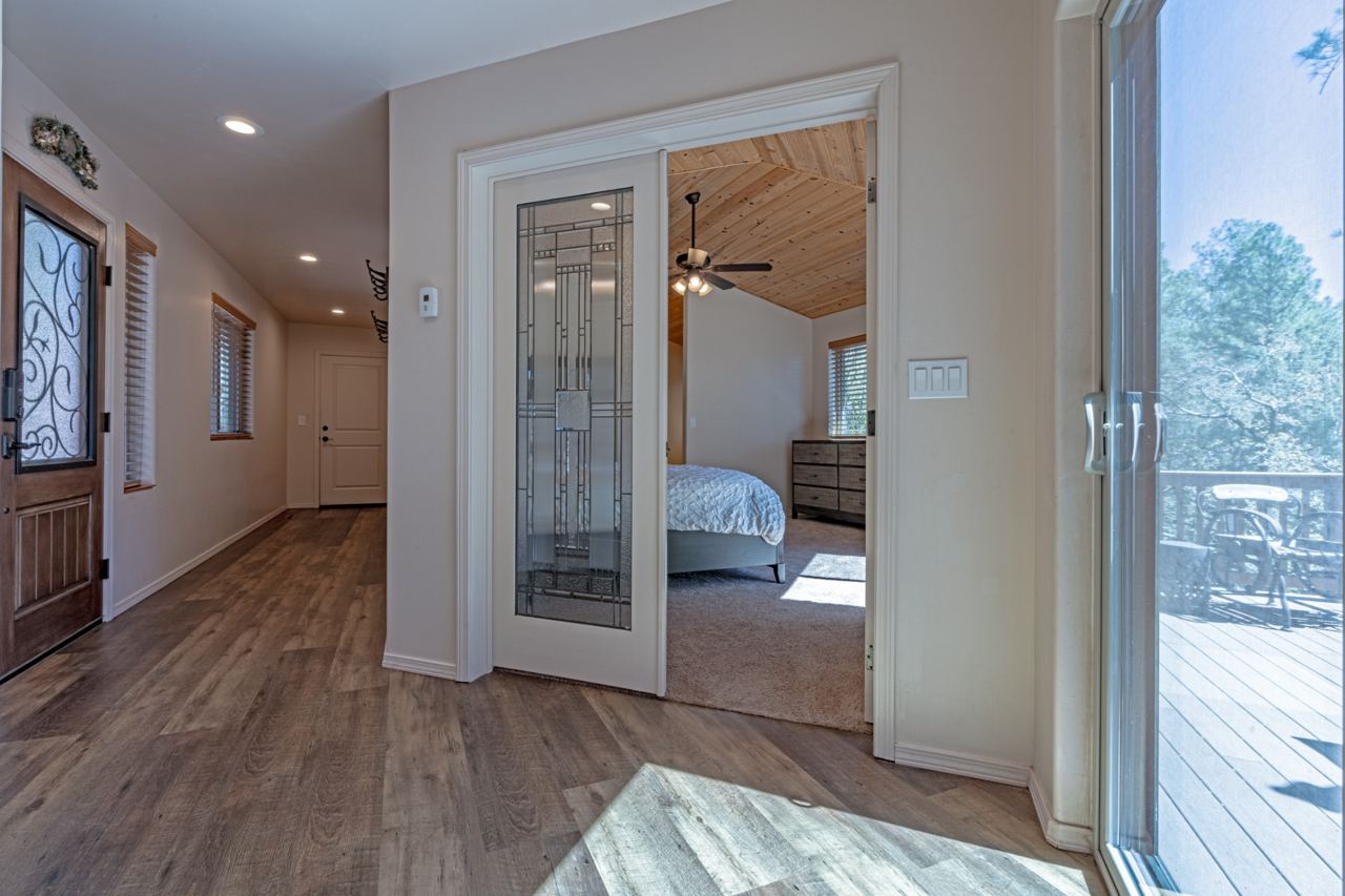 Entry hallway with decorative glass door toward bedroom and deck
