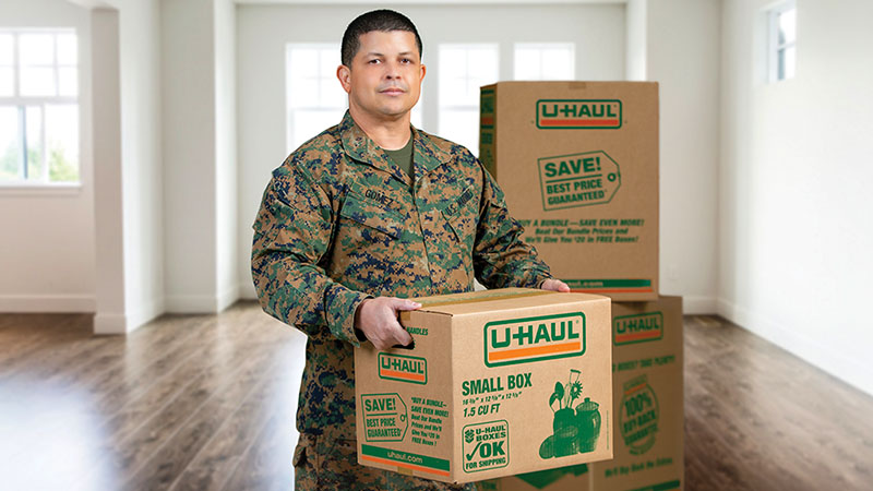 Military member holding moving box during a PCS move to Fort Meade Maryland