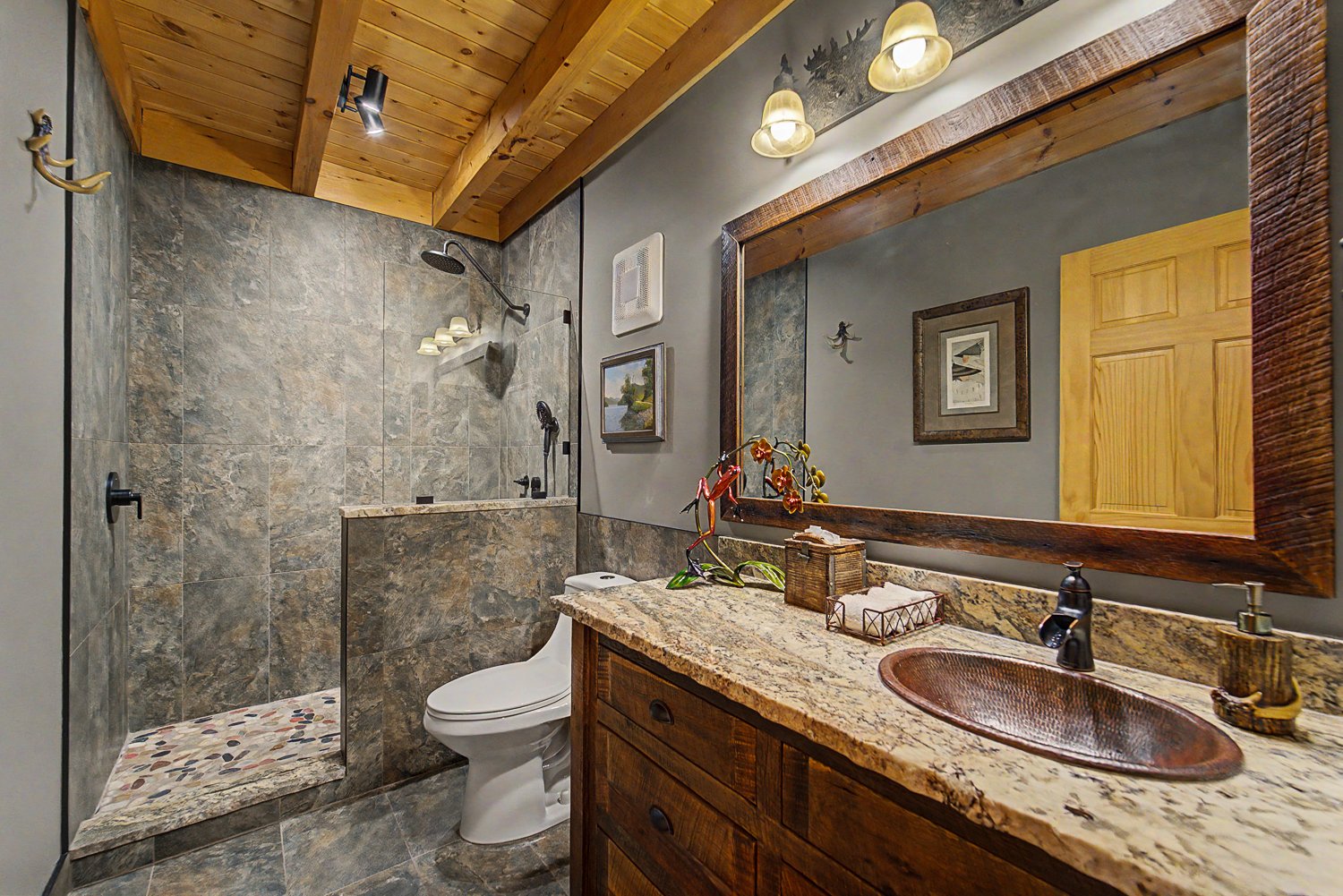 Bathroom with a tiled walk-in shower and copper sink