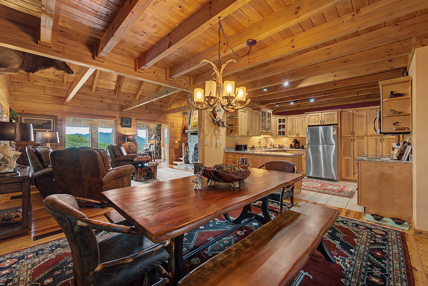 Dining area with a long wood table under exposed beams