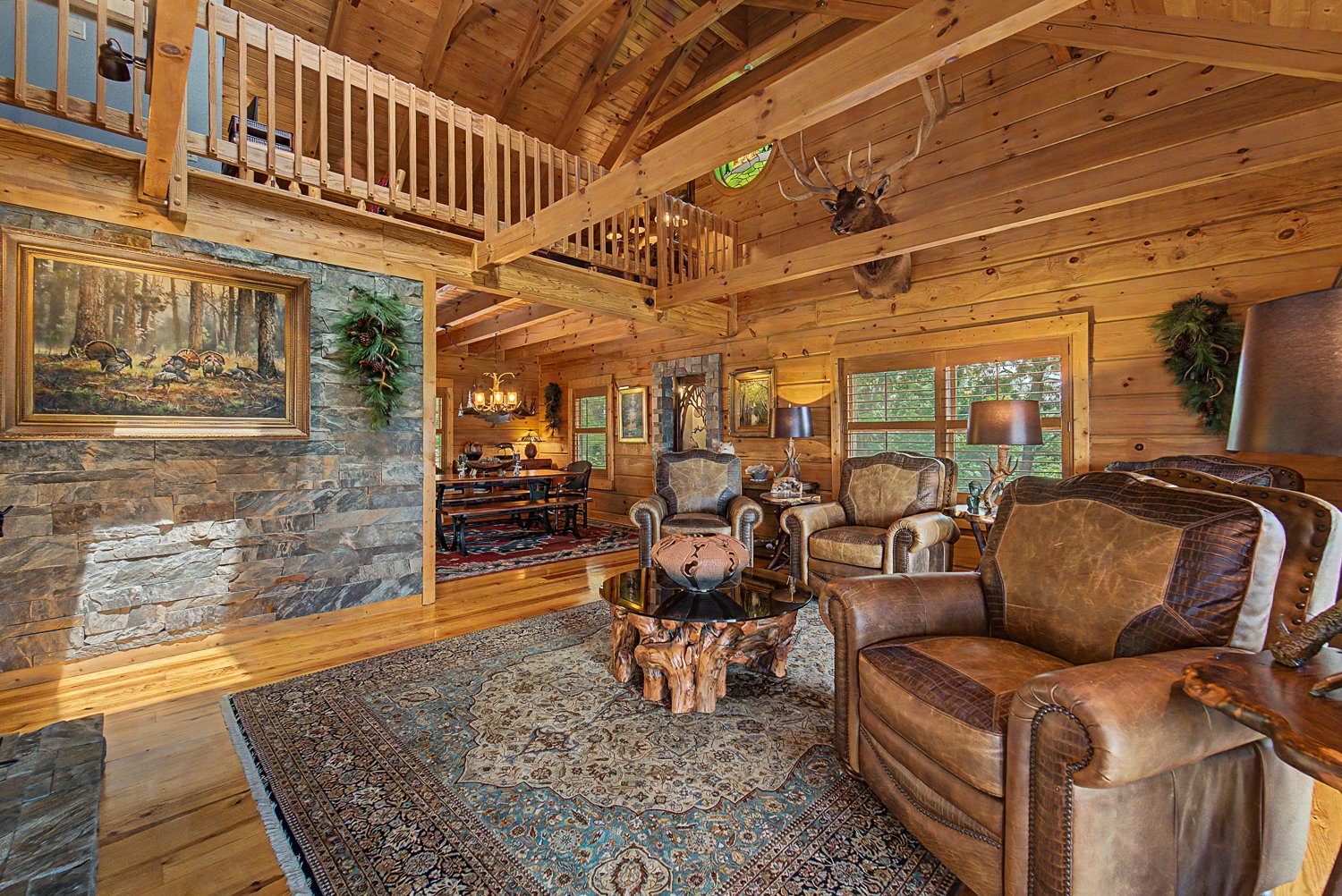 Great room at 220 Ridge Top Drive with a stacked-stone wood-burning fireplace and exposed beams