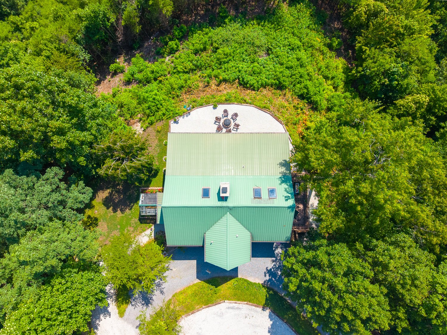 Overhead aerial of 220 Ridge Top Drive on its wooded knoll and gravel drive