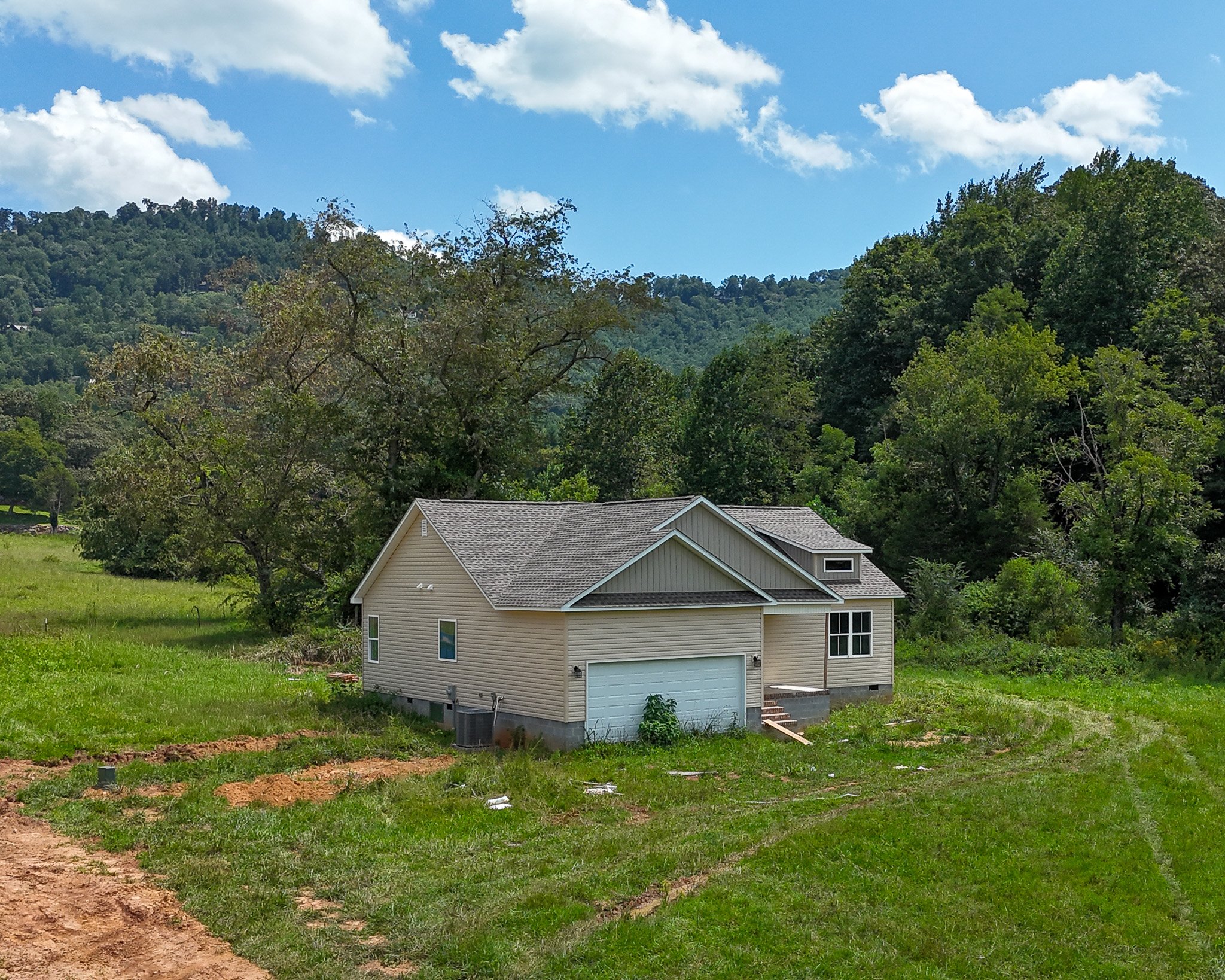 Aerial of the new home at 53 Meadow Ridge Road with wooded hills behind it