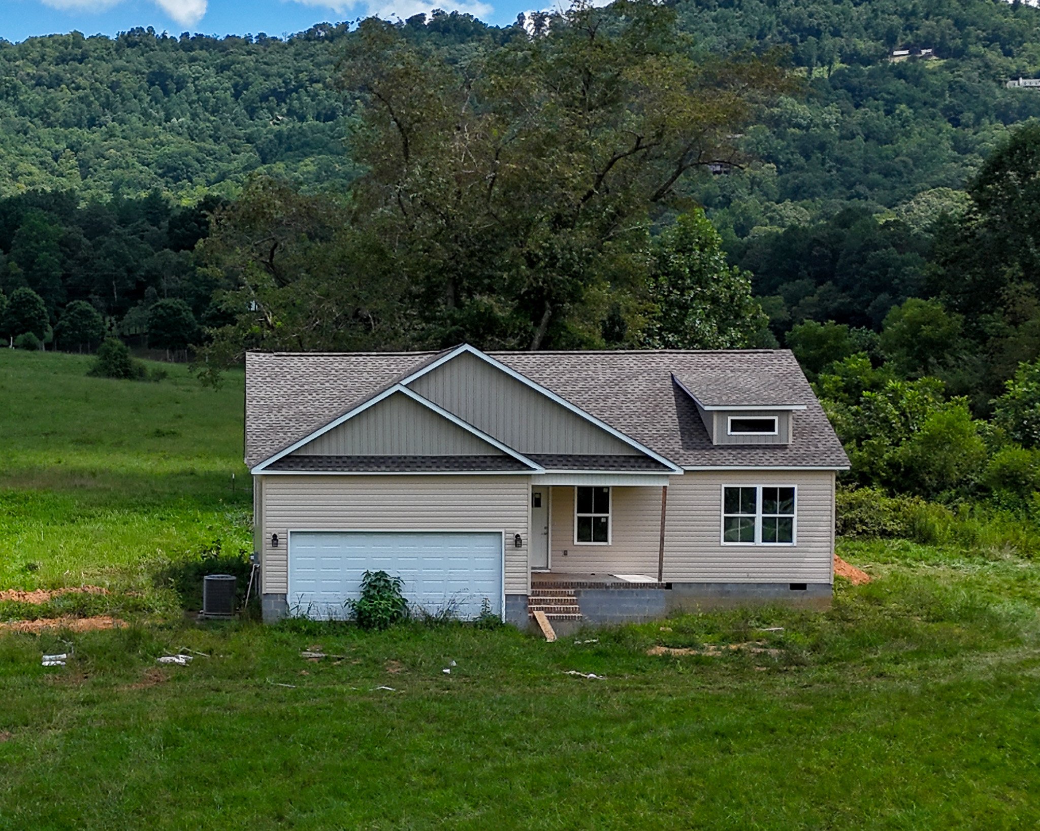 Aerial of the 1.48 acre lot at 53 Meadow Ridge Road with open lawn and wooded mountains behind