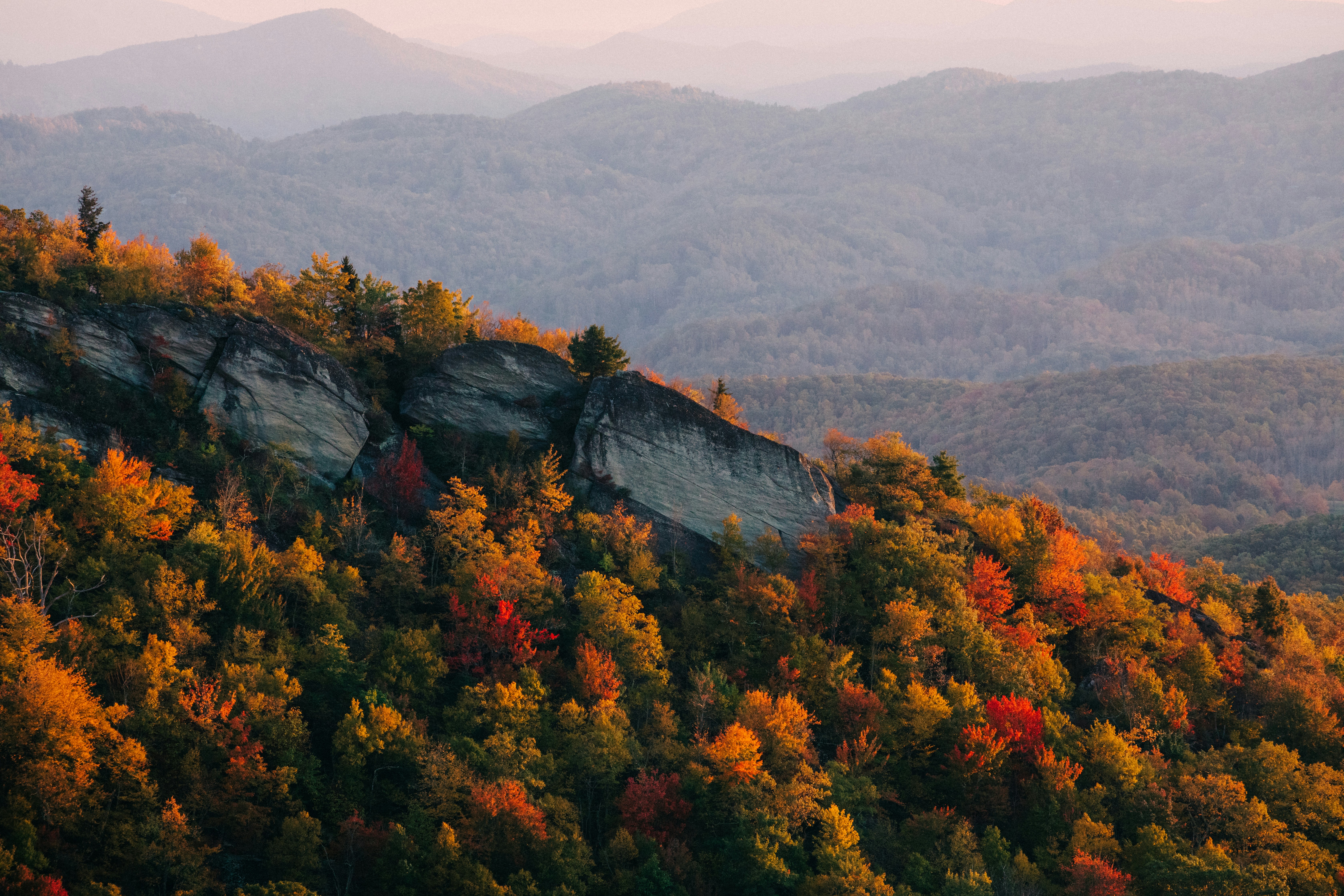 Mount Pisgah rising above layered blue ridges and open pasture in western Buncombe County, North Carolina.