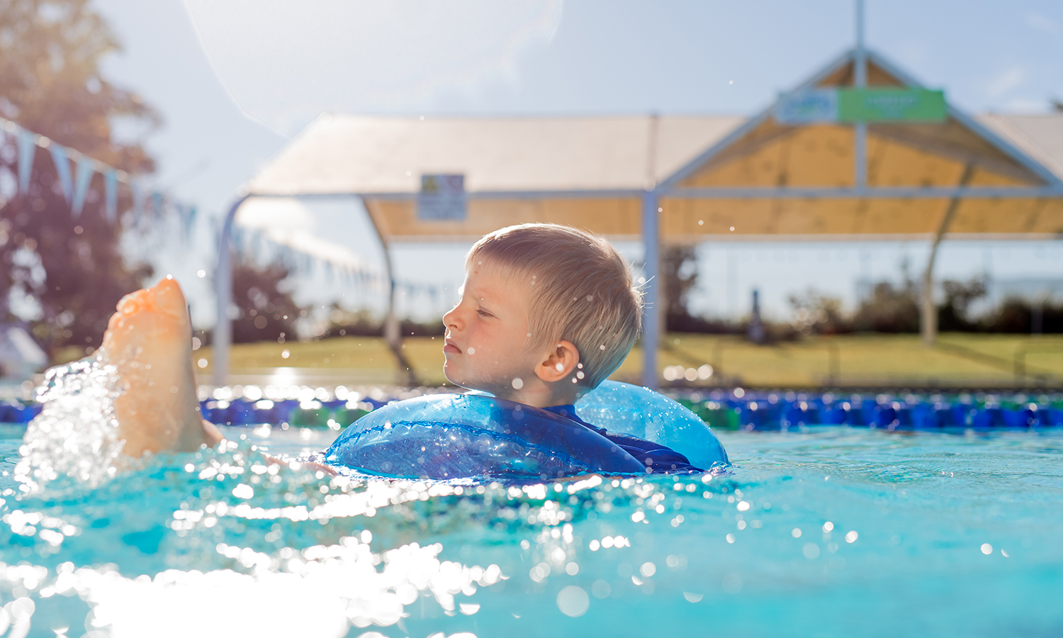 cute boy swimming in the pool with a float