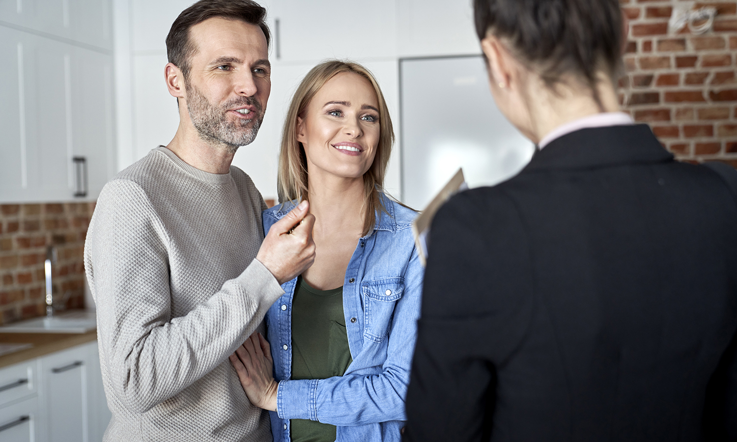 couple asking a realtor if they should sell their house as is or fix it up