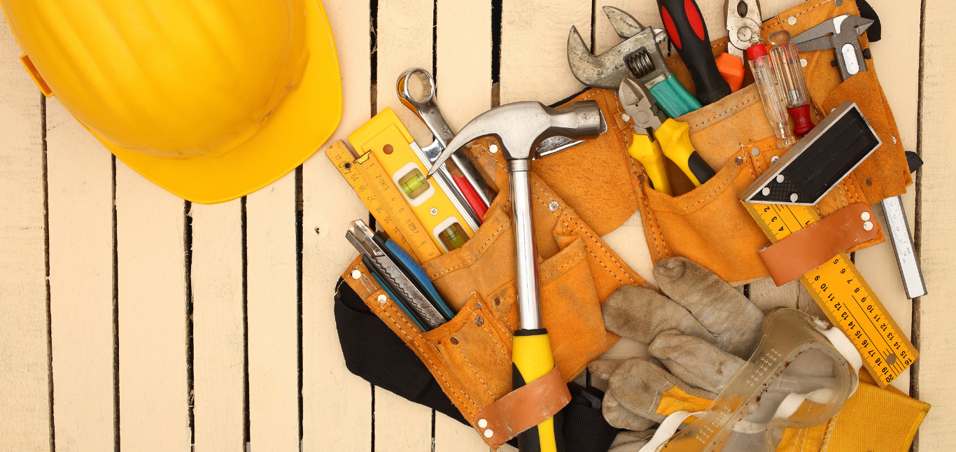 Flat lay of hand tools and a hard hat representing hands-on property maintenance