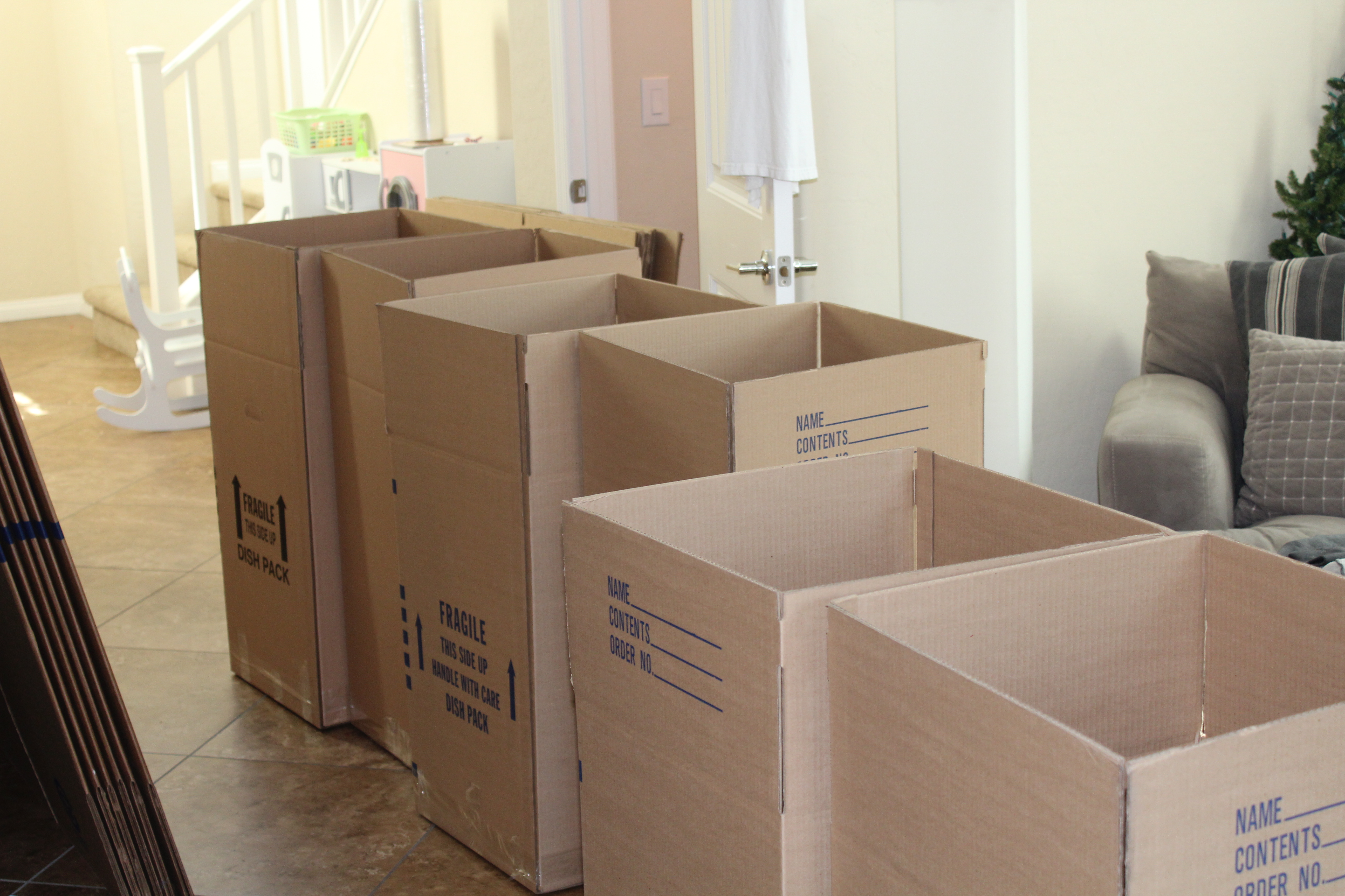 Cardboard moving boxes in a residential living area as a family prepares for a home sale