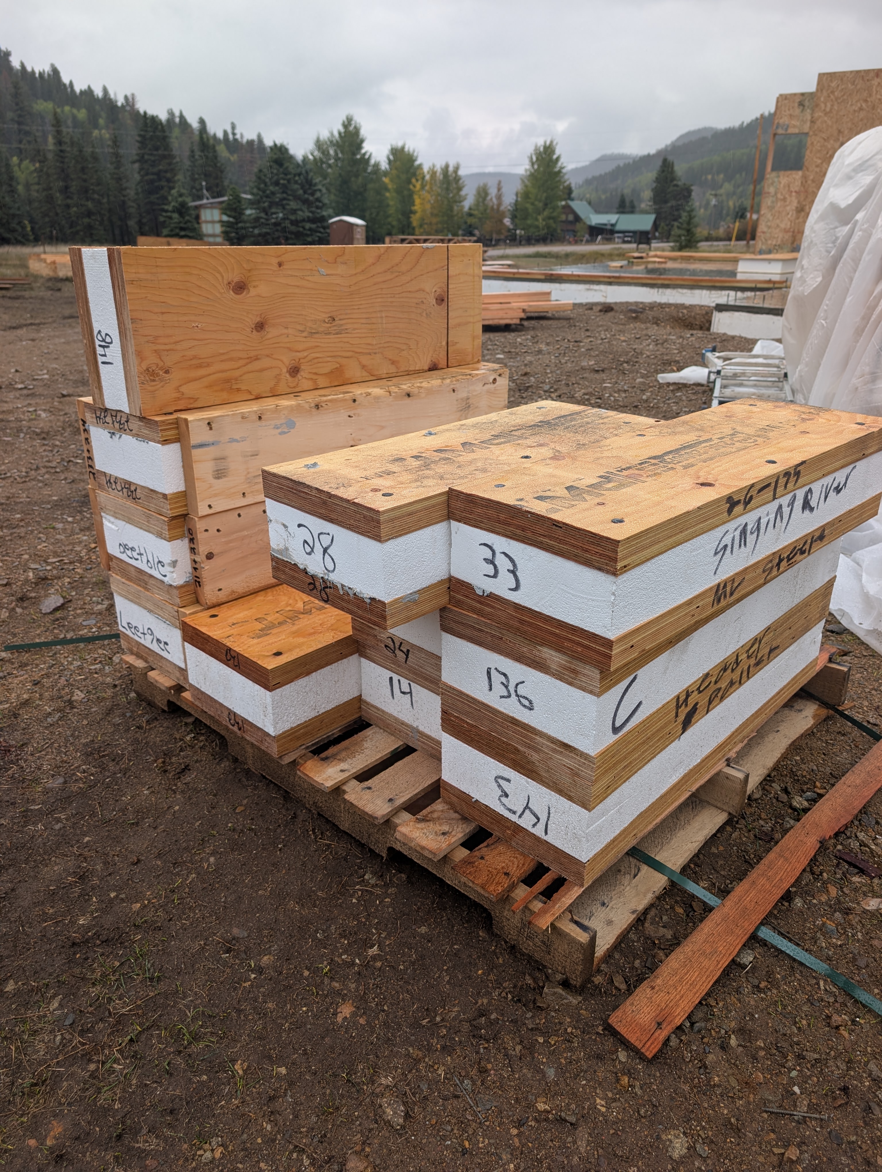 Numbered SIP panel pieces stacked on a pallet at the job site